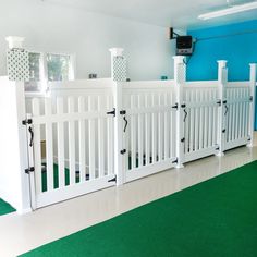 a room with white gates and green carpet