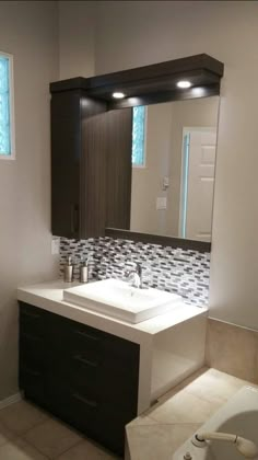 a bathroom with a sink, mirror and bathtub in the middle of the room