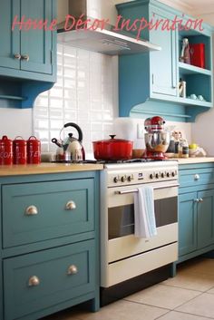 a kitchen with teal cabinets and white stove top oven, blue cupboards and tile flooring