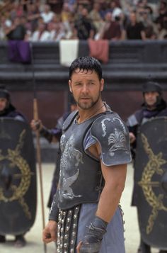 a man dressed in roman armor standing next to other men