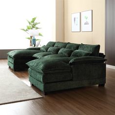 a large green couch sitting on top of a hard wood floor next to a window