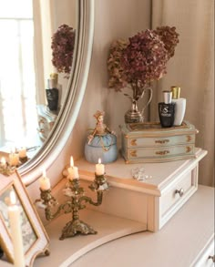 a dresser with candles and flowers on it