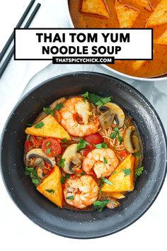 thai noodle soup with shrimp and vegetables in a black bowl on a white table