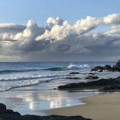 the beach has waves coming in and out of the water, with rocks on both sides