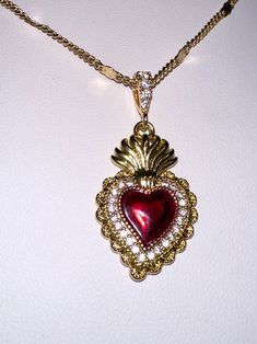 A beautiful 14k gold and red enamel sacred heart necklace on a 14k gold filled curb chain. Featuring cubic zirconia pave detailing on the pendant.Chain length: 17.5 Inch Gothic Vintage Jewelry, Sacred Heart Dangle Earrings, Luxury Antique Necklaces With Heart Charm, Luxury Vintage Red Necklaces, Red And Gold Accessories, Queen Of Hearts Necklace, Red Jewel Necklace, Sacred Heart Earrings, Sacred Heart Jewelry