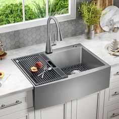 a stainless steel sink in a kitchen with marble counter tops