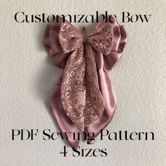 a pink bow is hanging on the wall with text that reads customizable bow pdf sewing pattern 4 sizes