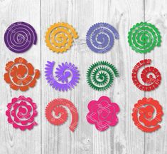 six different colored paper flowers on a white wooden background with text that reads freebied