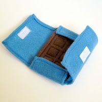 a small blue felt case with a brown door in it on a white table top