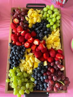 a wooden tray filled with lots of different types of fruit