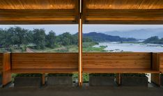 two wooden benches sitting next to each other under a roof