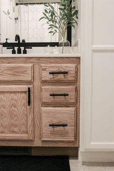 a bathroom with a sink, mirror and wooden cabinet