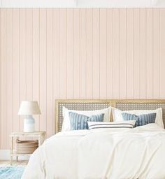 a bedroom with pink walls and white bedding