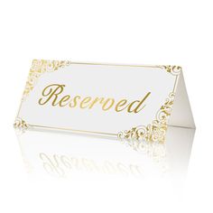 a white and gold reserved card with the word reserved on it