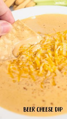 a person dipping cheese into a bowl of soup