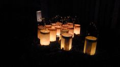 many lit candles are arranged in the dark