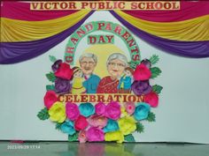 an old couple is sitting in front of a sign for the grand parents day celebration