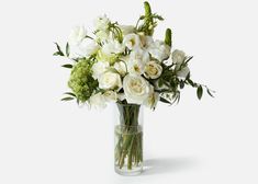 a vase filled with white flowers and greenery