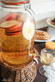 a jar filled with sparkling cider sitting on top of a table next to pine cones