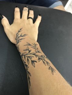 a woman's hand with a tattoo on it sitting next to a black table