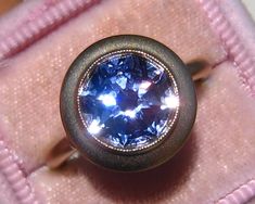 "This sleek Bezel ring combines fluid gold shapes with a pop of color from a custom-cut center stone. The sample ring is shown with a 9mm jubilee-cut lab blue sapphire. It can be made with any center stone though. I put some choices of 9mm jubilee-cut lab gems or moissanites in the pull-down menu, they will be custom-cut for your order. This ring can also be made with any size and shape center stone, you can buy this listing as \"mount only\" and add another center stone to it. I can also make i Modern Sapphire Ring With Bezel Setting For Formal Events, Modern Tanzanite Jewelry For Wedding, Modern Tanzanite Wedding Jewelry, Modern Tanzanite Rings, Modern Blue Sapphire Ring With Bezel Setting, Modern Sapphire Ring With Bezel Setting For Anniversary, Wedding Jewelry With Tanzanite In Bezel Setting, Formal Fusion Style Sapphire Ring, Formal Tanzanite Ring With Bezel Setting