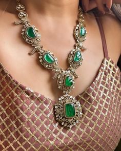 This exquisite Victorian doublets statement necklace set in emerald green captures the essence of opulence and vintage charm. The necklace, crafted with meticulous detail, features gleaming emerald green doublets set in an ornate Victorian-style framework. Each doublet, with its rich hue and intricate facets, reflects light beautifully, creating a mesmerizing play of colors.  The necklace cascades gracefully, adorned with smaller emerald accents and delicate filigree patterns that evoke the gran Formal Jewelry With Intricate Design And Emerald, Formal Emerald Jewelry With Intricate Design, Formal Intricate Emerald Jewelry, Elegant Jeweled Emerald Jewelry, Elegant Jeweled Emerald Necklace, Elegant Emerald Jeweled Necklaces, Elegant Formal Emerald Necklace With Intricate Design, Traditional Formal Emerald Necklace, Elegant Jeweled Green Emerald Necklace