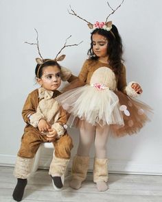 two children dressed up as reindeers sitting next to each other