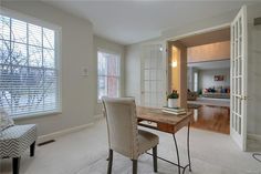 a dining room table and chairs in front of two windows