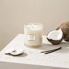 coconuts and a candle sit on a table