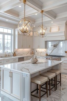 a large kitchen with marble counter tops and white cabinets, chandeliers above the island