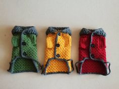 three crocheted dog clothes sitting next to each other