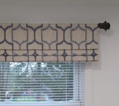 the window is covered with an intricate valance, and has a decorative pattern on it