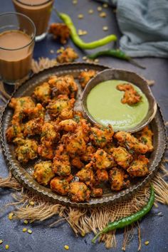 a plate full of fried food with dipping sauce