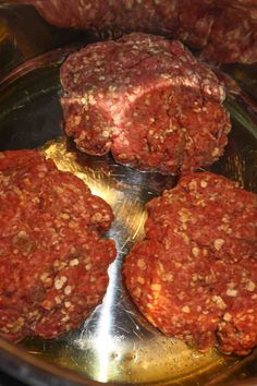 three hamburger patties are in the middle of a frying pan with other meat patties