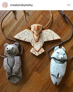 three ornaments made out of clay on a wooden floor, including two bears and one bear