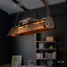 an industrial light fixture hanging from the ceiling in a room with bookshelves and shelves