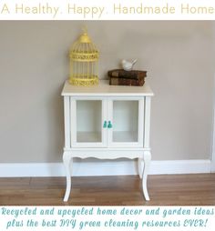 a birdcage sitting on top of a white cabinet