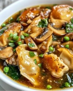 a white bowl filled with dumplings and vegetables