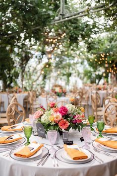 the table is set with plates and napkins for an elegant wedding reception at the park