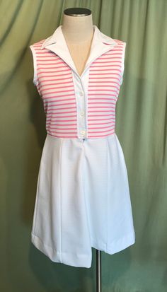 "This is a cute vintage dress from the early 70s. No Brand label only a care & size tag. Tagged a size 14. The bust measures 36\", waist 30\", see measurements below, but it would look best on a slightly smaller bust & waist. Made of a pink & white polyester. The dress is a zip & button front shirt dress. It buttons to the waist & below that is a short nylon zipper. It is sleeveless with a lapel style collar. The top half is pink & white horizontal stripe & the skirt White A-line Retro Vintage Dress, Vintage White A-line Sleeveless Dress, White Retro Sleeveless Spring Dress, White Retro A-line Vintage Dress, White Retro Sleeveless Dress, White A-line Vintage Retro Dress, White Sleeveless Mod Dress, White Sleeveless Vintage Dress For Daywear, Retro Sleeveless Vintage Dress For Daywear