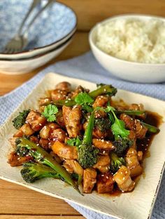 chicken and broccoli stir - fry on a plate with rice in the background