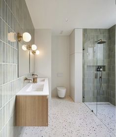 a bathroom with two sinks, a toilet and a walk in shower stall next to each other