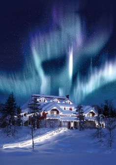 the aurora bore is shining brightly in the sky above a snowy house with lights on it