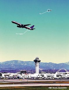 an airplane is flying over the airport with mountains in the background