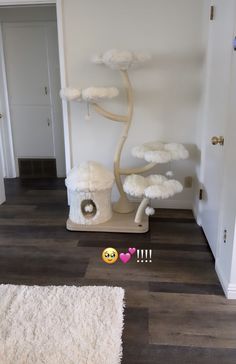 there is a cat bed in the middle of the floor with clouds on it and a house shaped like a tree