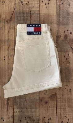 "High waisted 90's denim shorts. Made by Tommy Hilfiger in pale yellow denim wash with classic large patch Tommy Hilfiger logo. Shorts are in excellent clean condition. Logos still bright and crisp in color. Wear as is or roll them up as shown in photos. Perfectly worn in with light naturally distressed character. Measurements (taken zipped or buttoned up and laid comfortably flat) inches x 2 for total circumference (inches) Tag Size 8 Tommy Hilfiger 100% Cotton Waist 29\" Hips 41\" Length 15\" White Cotton Jean Shorts With Belt Loops, Retro White Shorts With Pockets, Vintage White Jean Shorts, 90s Style Straight Leg Cotton Shorts, Vintage Straight Leg Cotton Shorts, 90s Style Cotton Straight Leg Shorts, Vintage White Jean Shorts For Spring, Vintage White Cotton Jean Shorts, Vintage Cotton Straight Leg Shorts