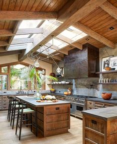 an open kitchen with lots of counter space and skylights above the island in the center