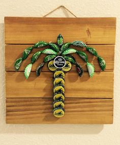 a wooden sign with a palm tree made out of soda cans on it's side