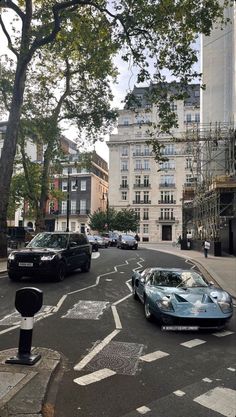 cars are parked on the street in front of tall buildings