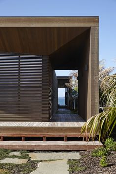 a wooden walkway leading to a house on the beach